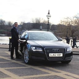Ervin Standing Next To A Black Audi In 2013, When He First Started EG Chauffeurs