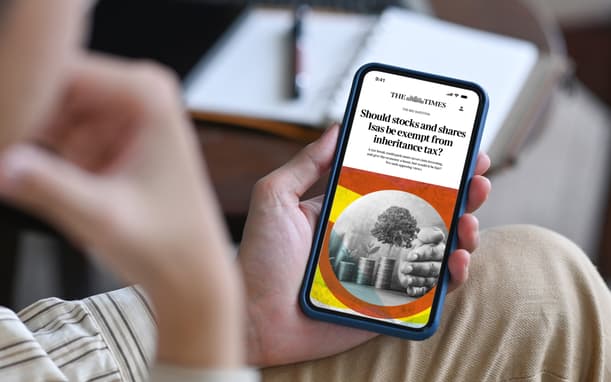 A Man Sitting Down Reading The Times On His Phone (1)