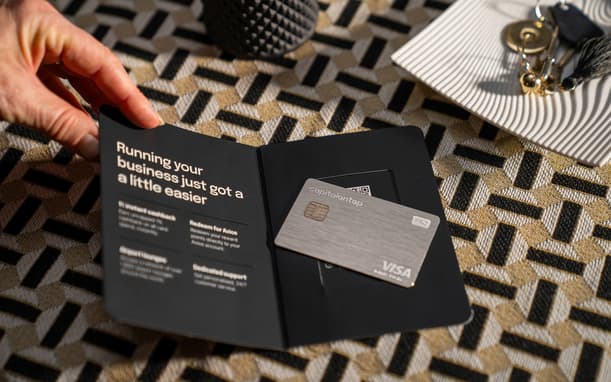 Hand Opening A Capital On Tap Welcome Pack Reading Running Your Business Just Got A Little Easier, With A Pro Metal Visa Card Resting On The Inside Cover