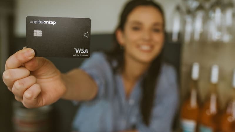 Woman In Wine Shop Holding Capital On Tap Business Credit Card