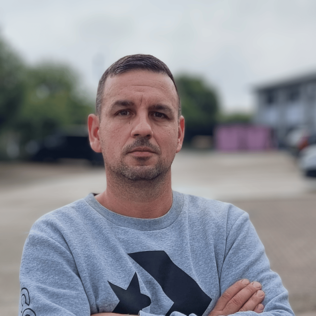 Sebastian, Founder Of Termopane Winodws, Standing In Front Of The Camera With His Arms Crossed
