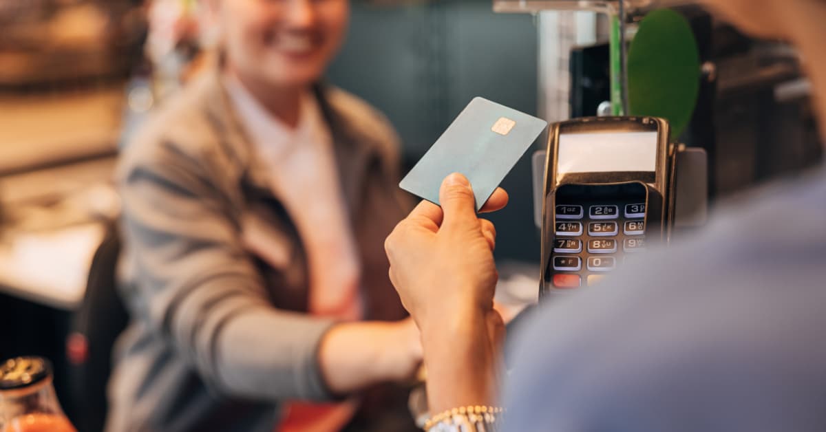 A Man Holding A Credit Card Paying In A Shop