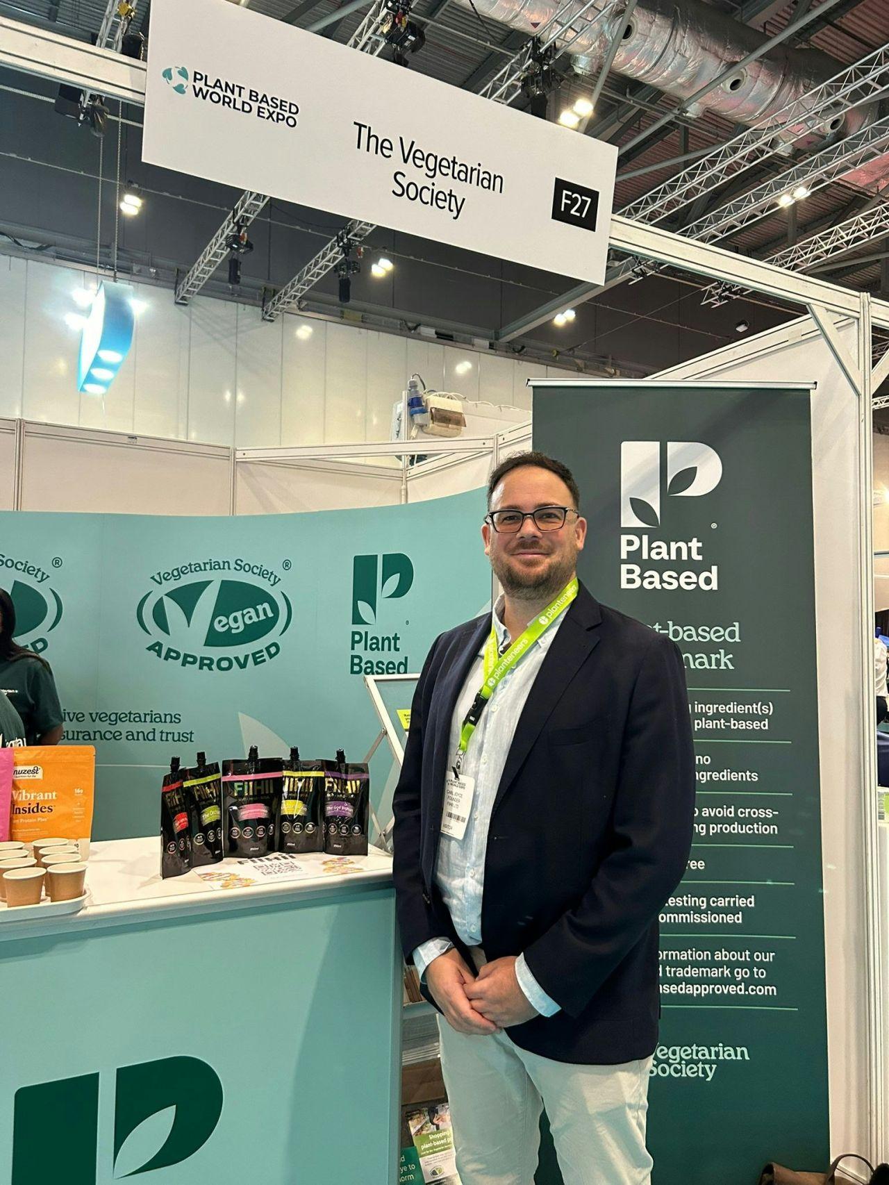 Carl From Fiihii Standing Next To A Stall Showcasing Is Brand And Products