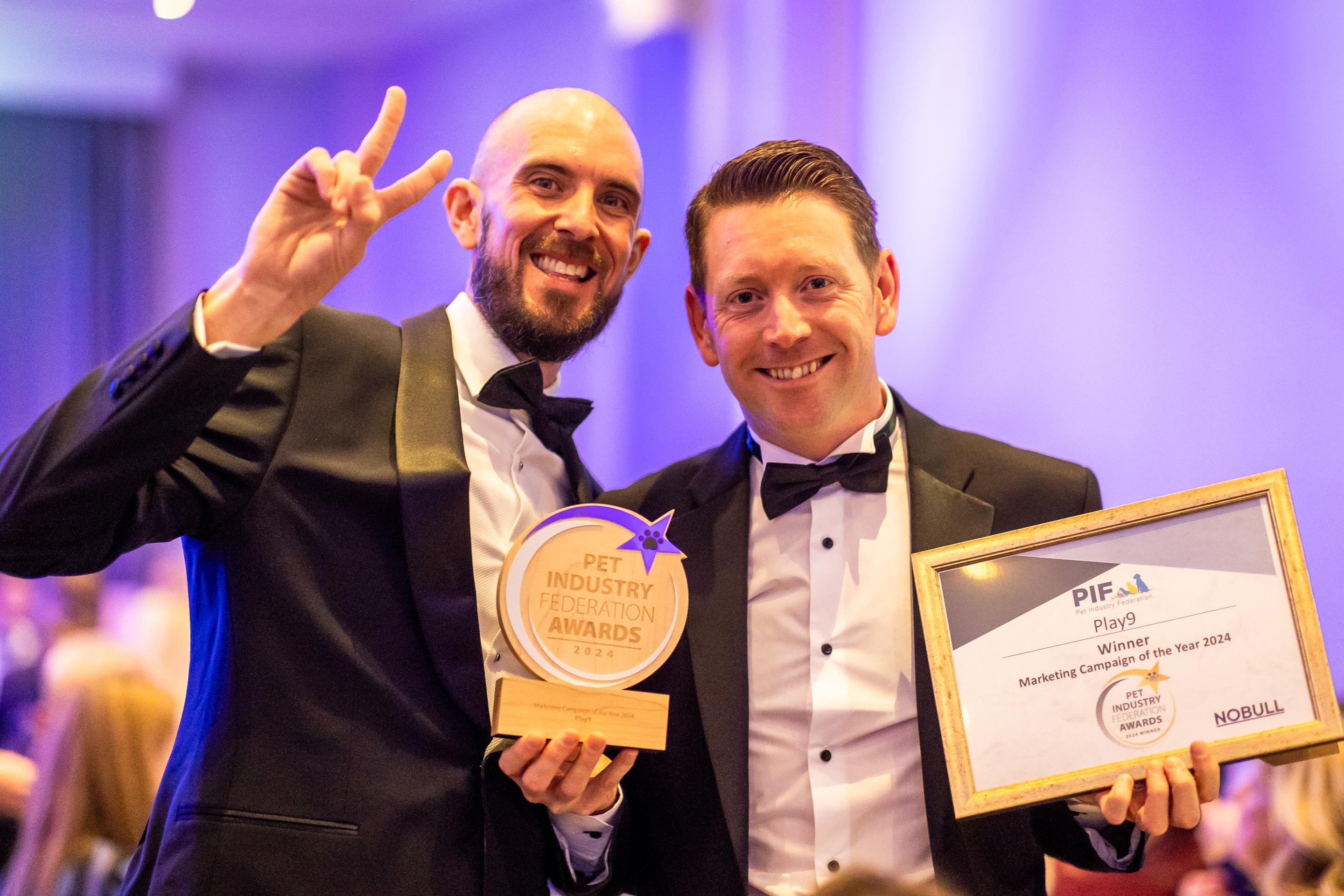 Lee, Owner Of Play9, Celebrating With A Colleague In Black Tie At An Awards Ceremony, Holding The Pet Industry Federation Award And Certificate For Marketing Campaign Of The Year 2024