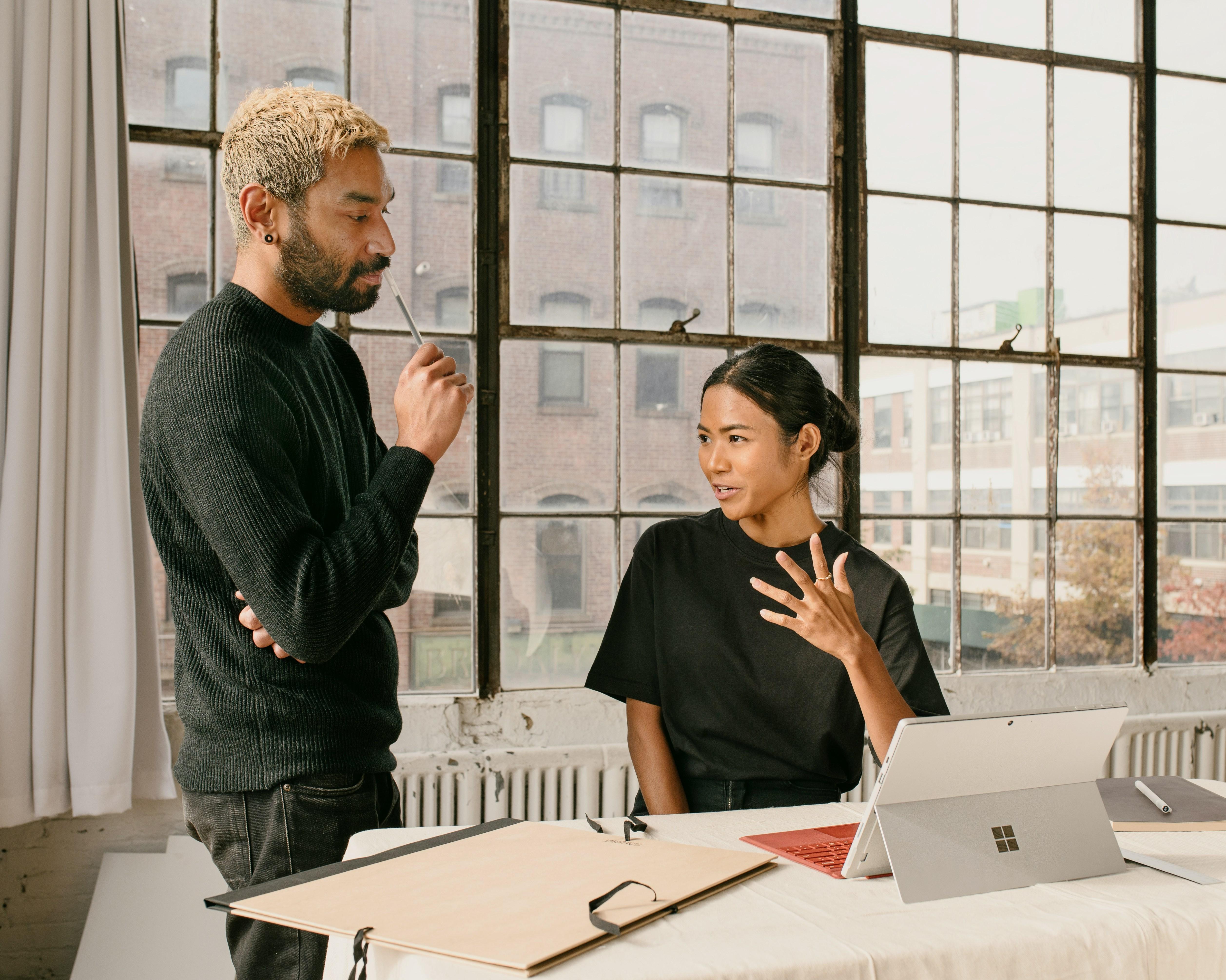 Two Colleagues Talking To Each Other In An Office Space
