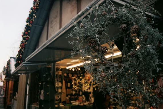 A Close Up Of A Wreath Hanging Outside A Christmas Market Stall