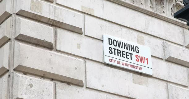 A Street Sign Showing Downing Street SW1 On A Street Corner
