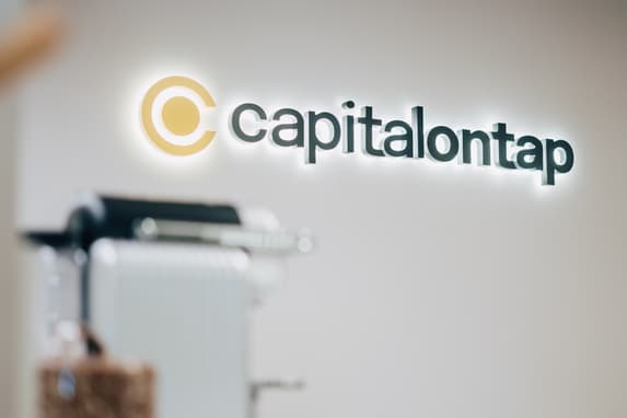 Capital On Tap Logo Sign With Backlighting On A Blank Wall