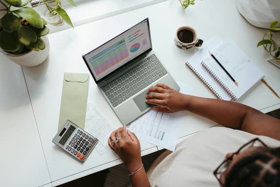 Small Business Owner Looking At Charts On Laptop