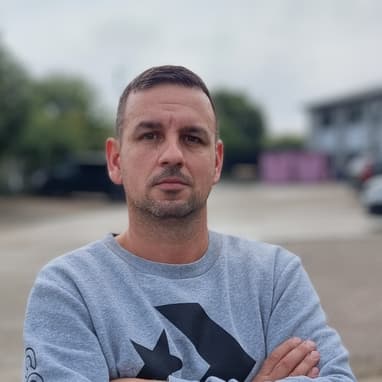 Sebastian, Founder Of Termopane Winodws, Standing In Front Of The Camera With His Arms Crossed