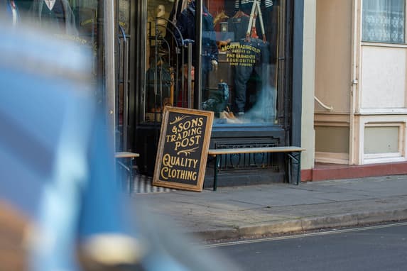 &Sons Trading Post Independent Clothing Shop Sign Outside A UK High Street Storefront