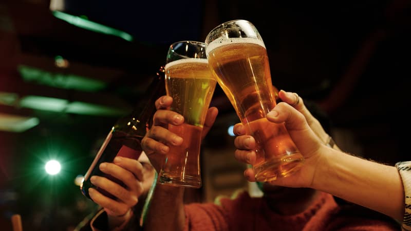 A Group Of Friends Lifting Up Their Pints To Cheers