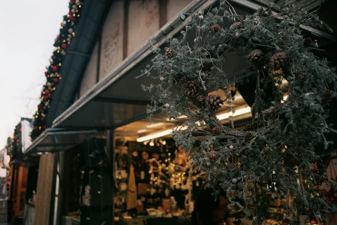 A Close Up Of A Wreath Hanging Outside A Christmas Market Stall