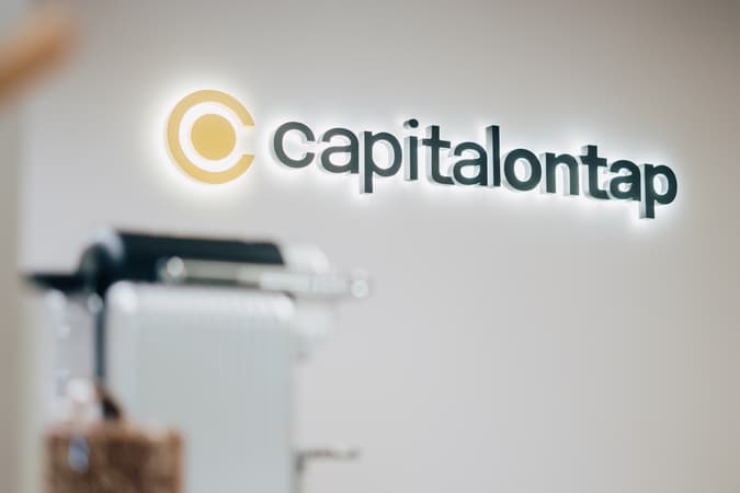 Capital On Tap Logo Sign With Backlighting On A Blank Wall