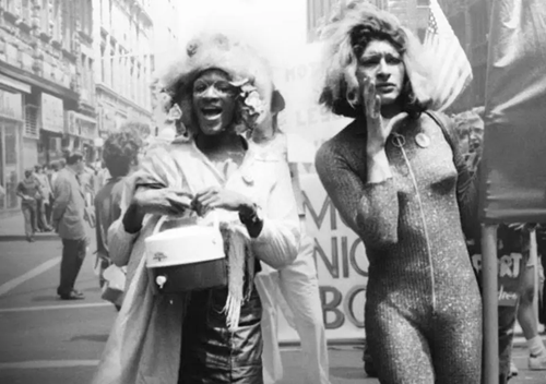 Marsha P. Johnson and a fellow drag queen at a march. The photo is in black and white