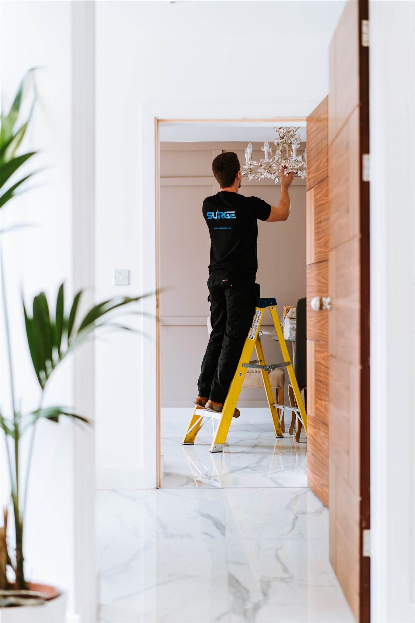 Surge engineer on a ladder fitting a light