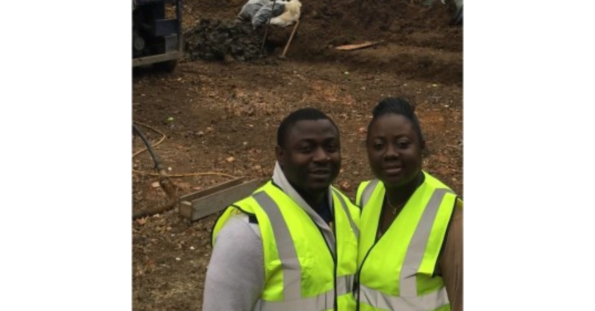 Toyin on a building site with a peer. They both wear hi-vis jackets