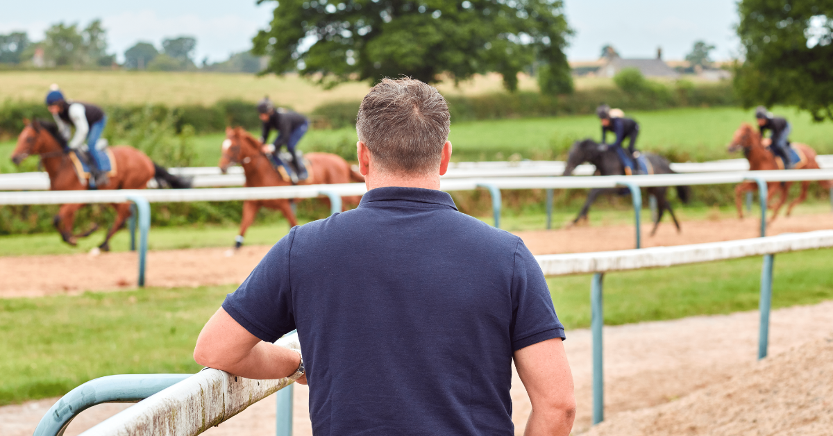 Michael Owen watching horse racing. there are 4 horses on the track